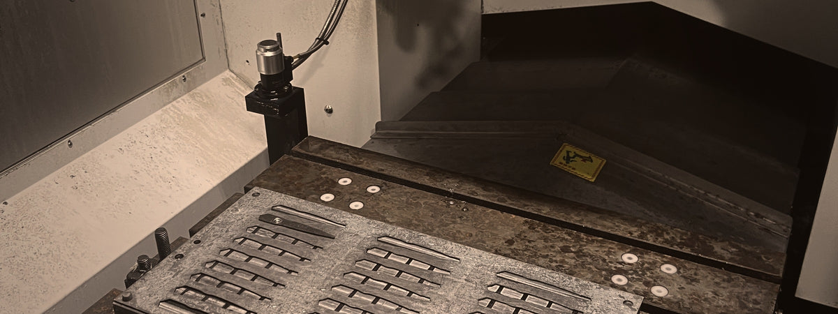 Precision machining fixture holding a batch of stainless shear components inside a CNC machine